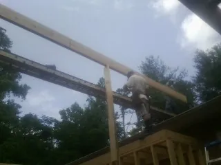 Carpenter setting a ridge beam over a new addition frame — Ice Dam Removal by Roofing Brothers in Deer Trail
