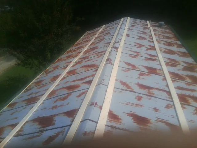 Rusted metal roof panels with new wood purlins before replacement — Storm Damage Roof Repair in Deer Trail by Roofing Brothers