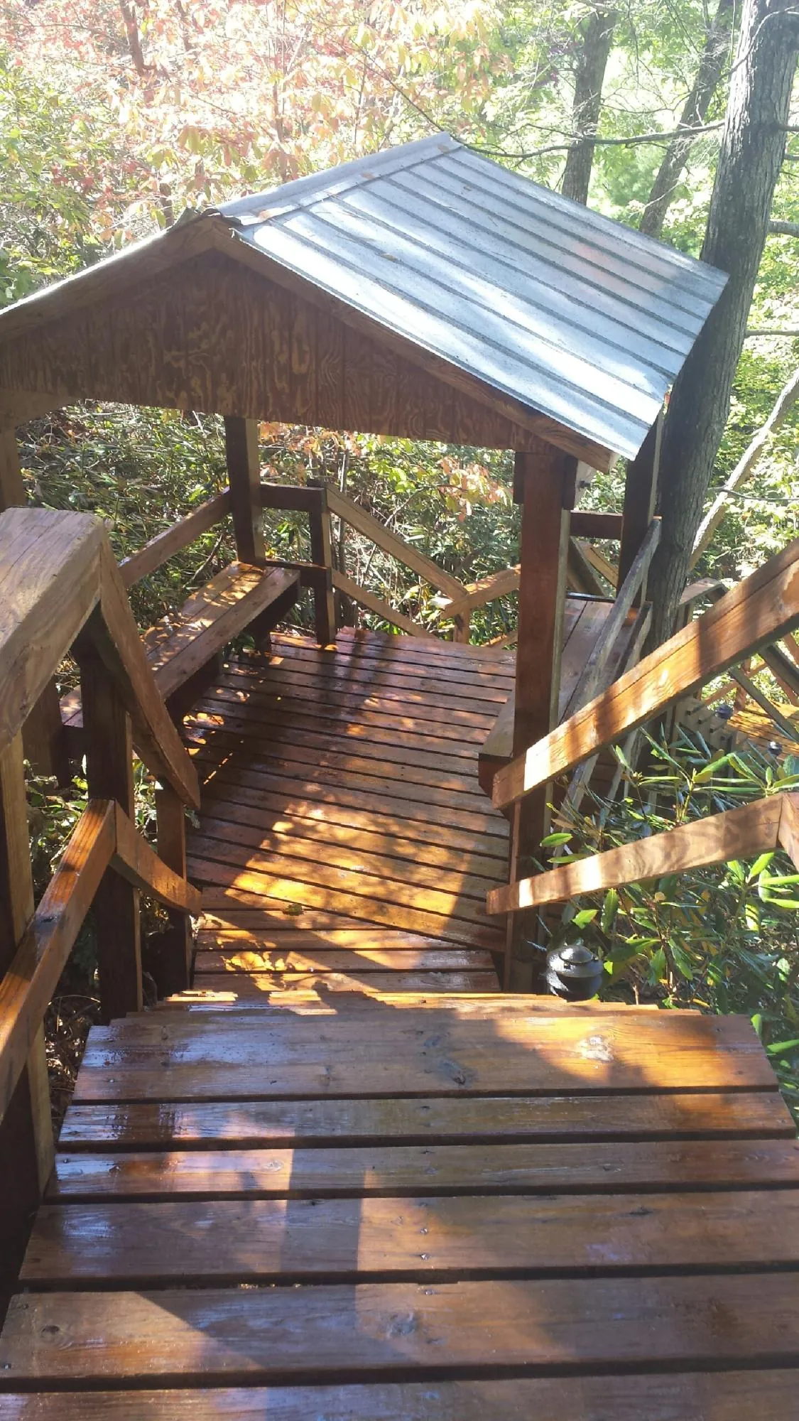 Freshly stained wood walkway and covered shelter with a metal roof in Deer Trail