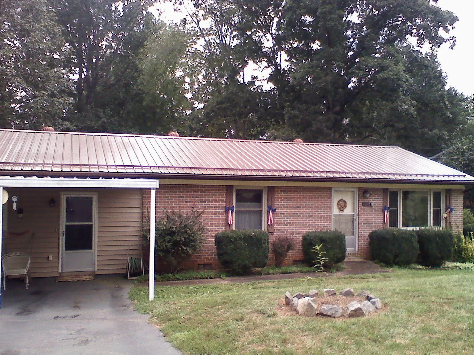Bronze metal roof and carport on a brick ranch home — Roof Repair work by our crew in Deer Trail